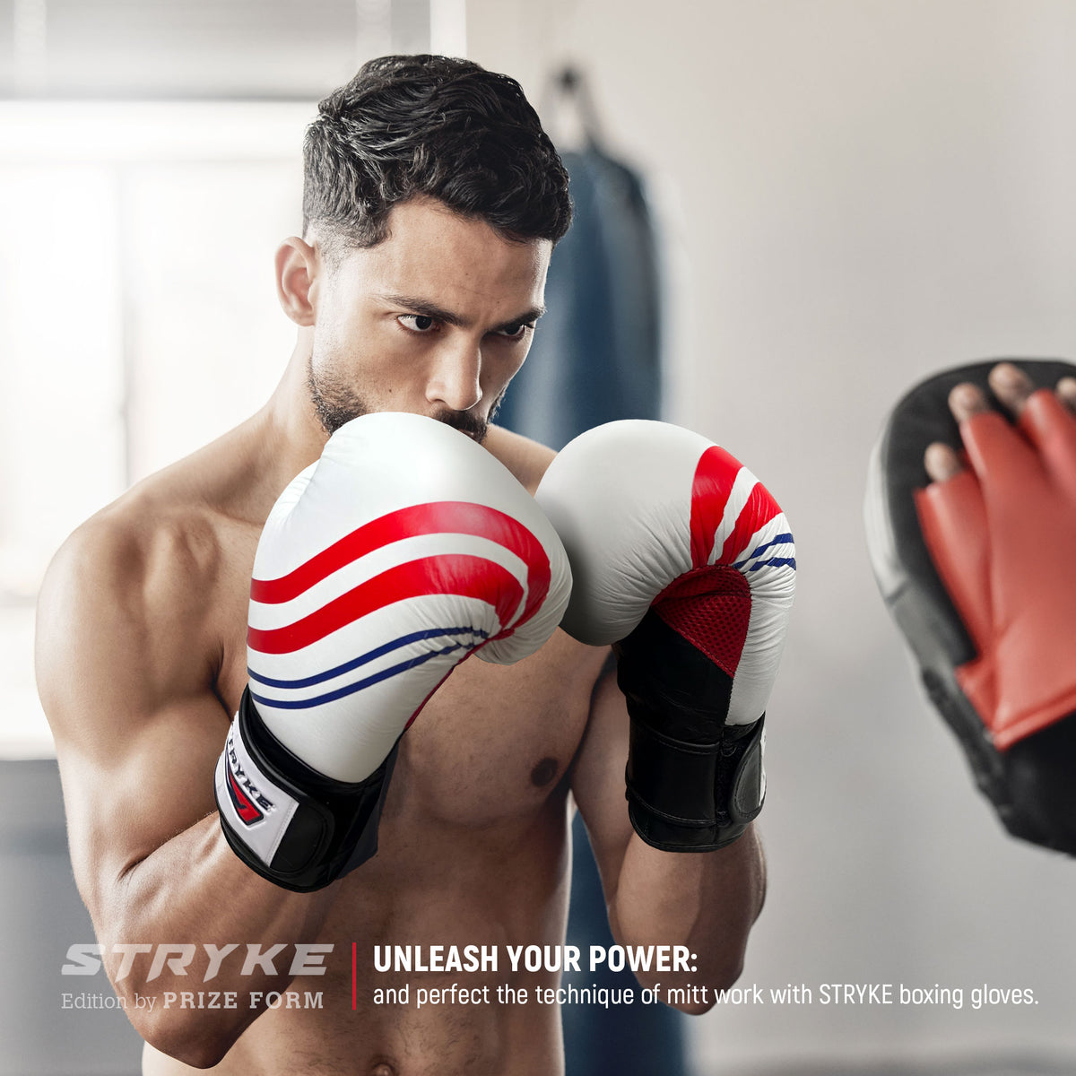 Man wearing STRYKE boxing gloves practicing with a focus mitt.